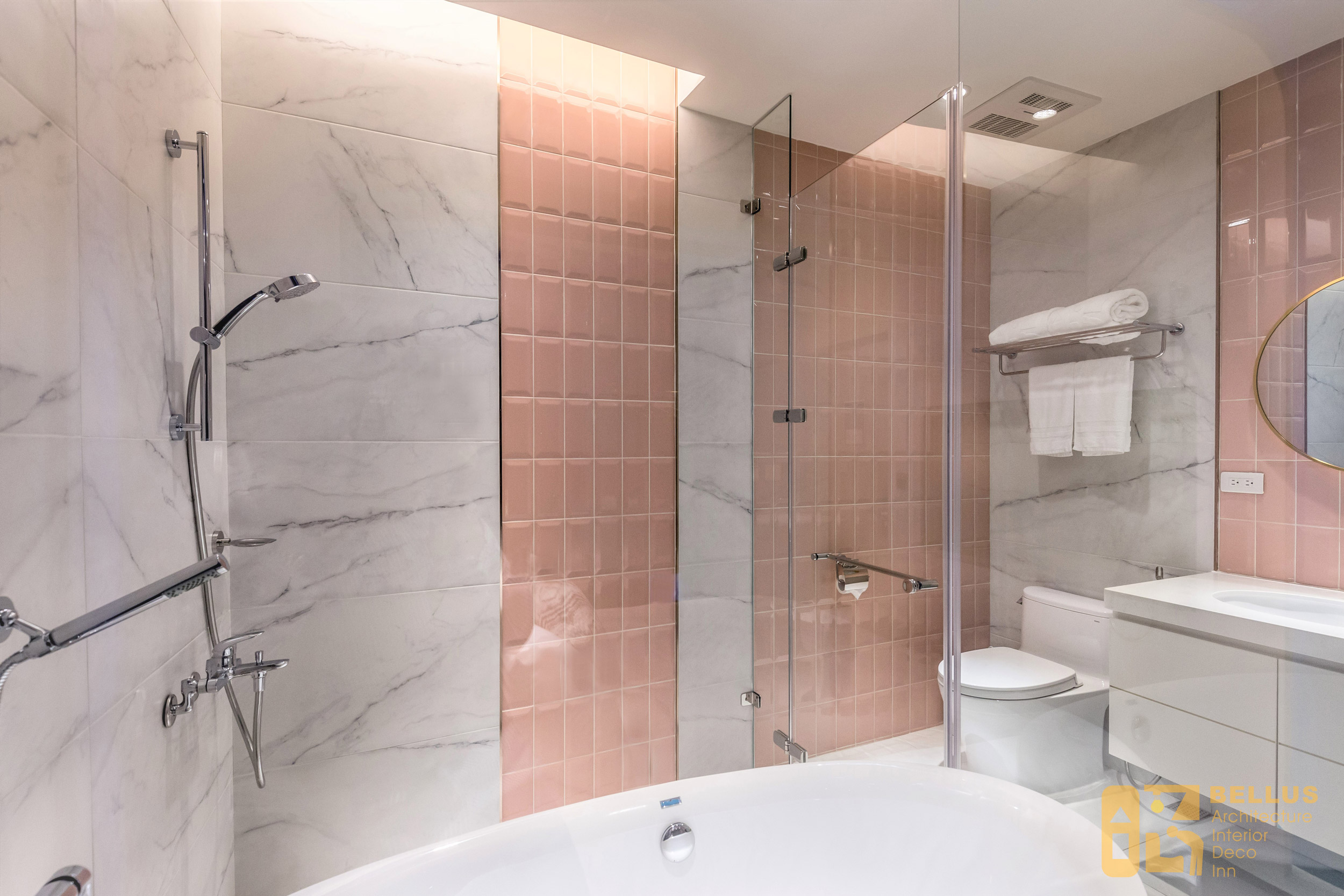 衛浴空間牆面使用粉色地鐵磚以及魚肚白大理石材，兩者搭配呈現活潑的空間氛圍